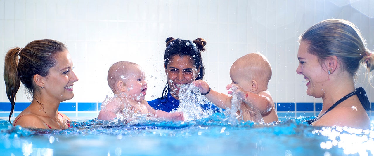 water babies swimming teacher with two babies splashing